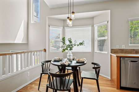 Eat-in kitchen with oak features, modern black accents, and a styled dining table with white plates and a greenery-filled vase, creating a modern farmhouse feel.
