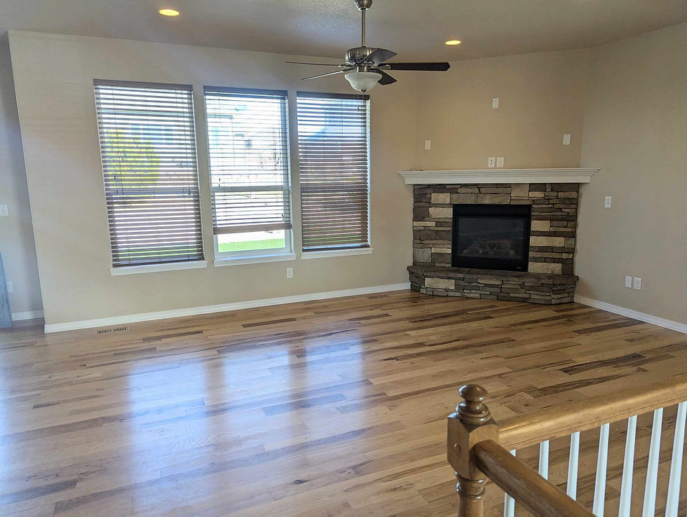 Empty small living room with angled fireplace and natural light