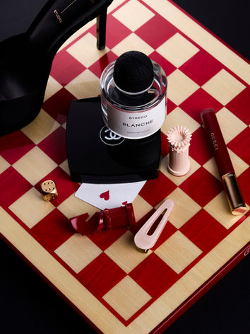 Mise en scène éditoriale de produits de beauté sur un damier d'echec réalisée par un studio de création spécialisé en photographie cosmétique et contenu make-up.
