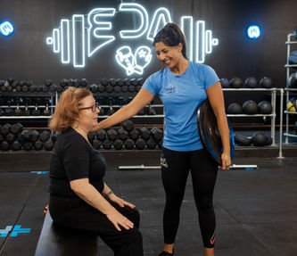PHF female personal trainer coaching her female client through exercise. Strength, Hyrox & CrossFit training, Glasgow