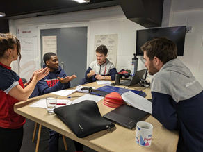 A group of 4 sports coaches sitting around a table practising the Makaton signs learned during Makaton training