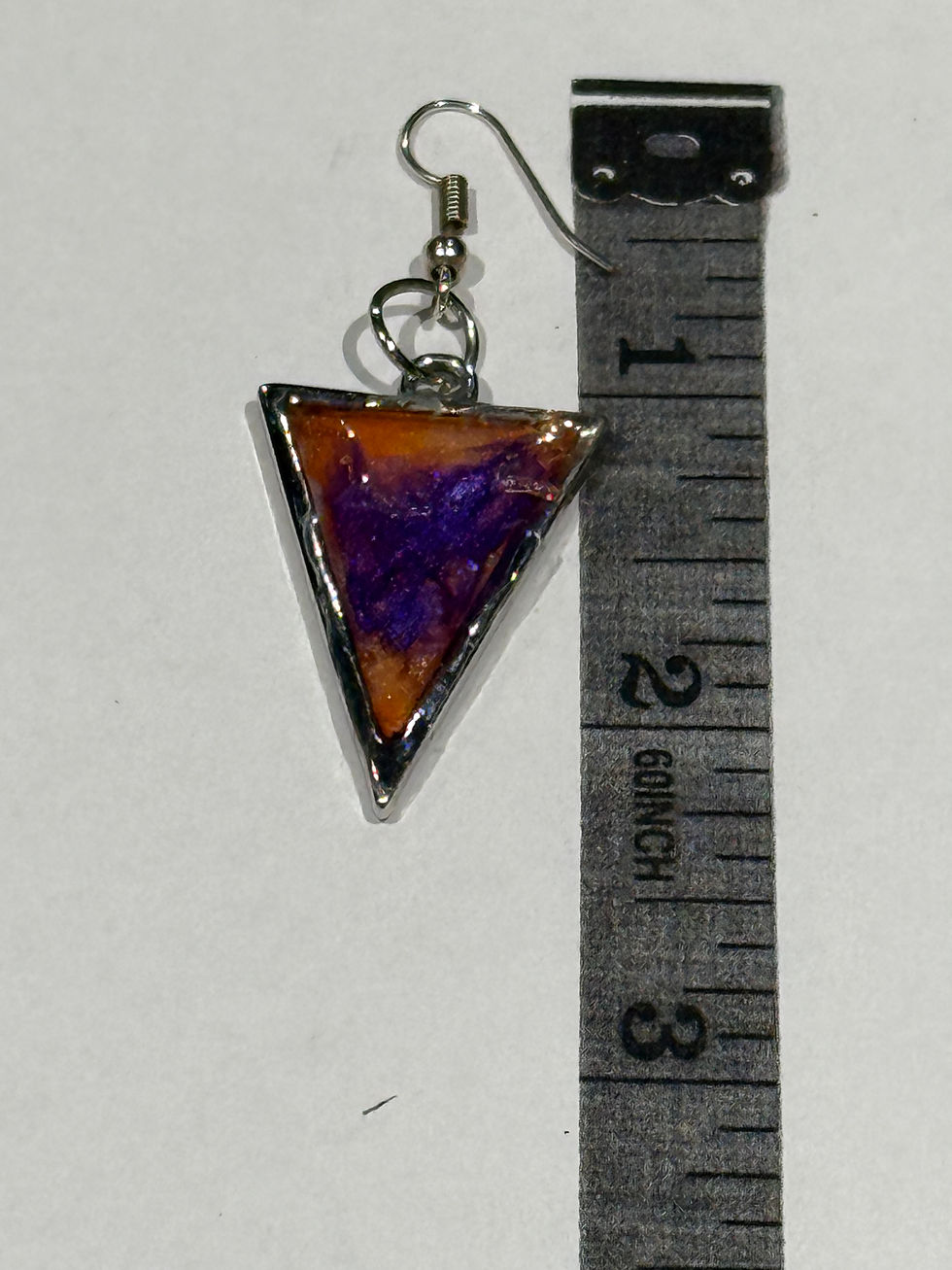 Thumbnail: Purple amber triangle resin earring shown beside ruler for size reference