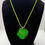 Thumbnail: Round clear resin pendant featuring a real preserved green leaf on neon green cord, botanical handmade necklace on black back