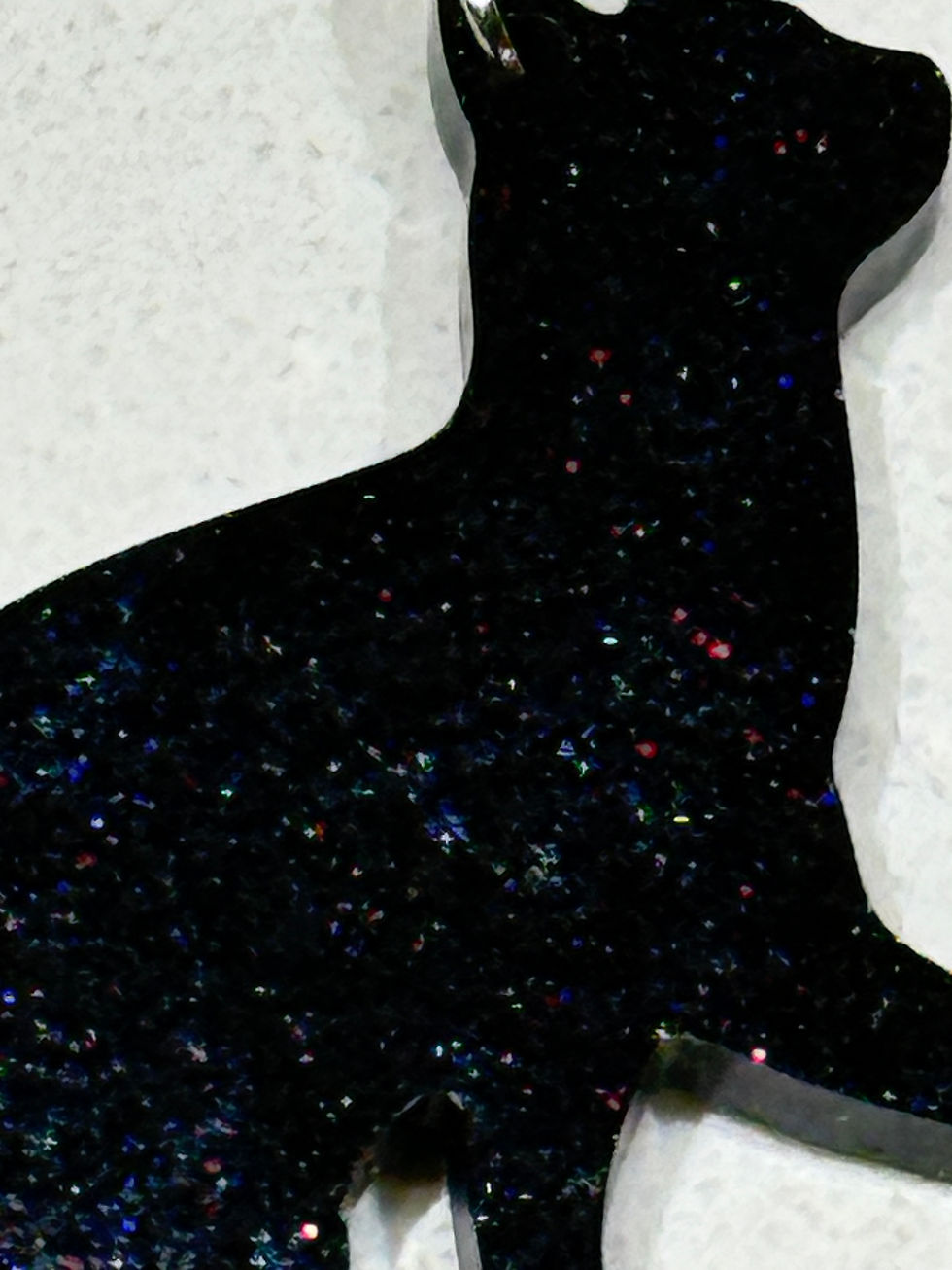 Thumbnail: Close-up of black resin cat earring showing red sparkle detail throughout