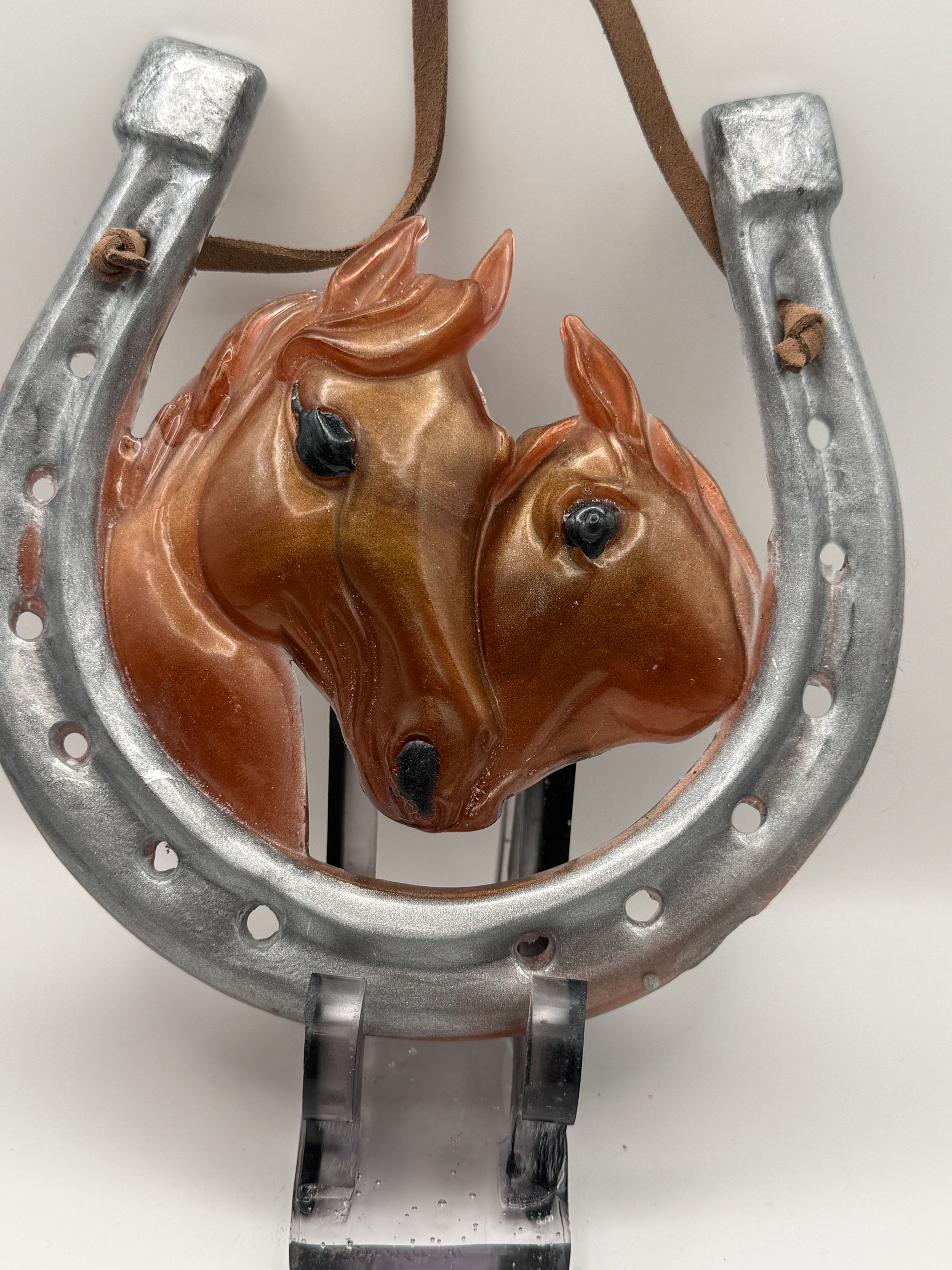 Western horseshoe ornament with two horse heads centerpiece displayed on stand