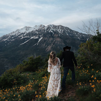 Utah Mountain Elopement Day among the wildflowers in Summer. Western Couple gets married in the mountains with yellow wildflowers. boho wedding dress and cowboy groom