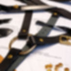 Leather strap-on harness pattern tools and hardware laid out on printable sewing pattern by Velvet Nest
