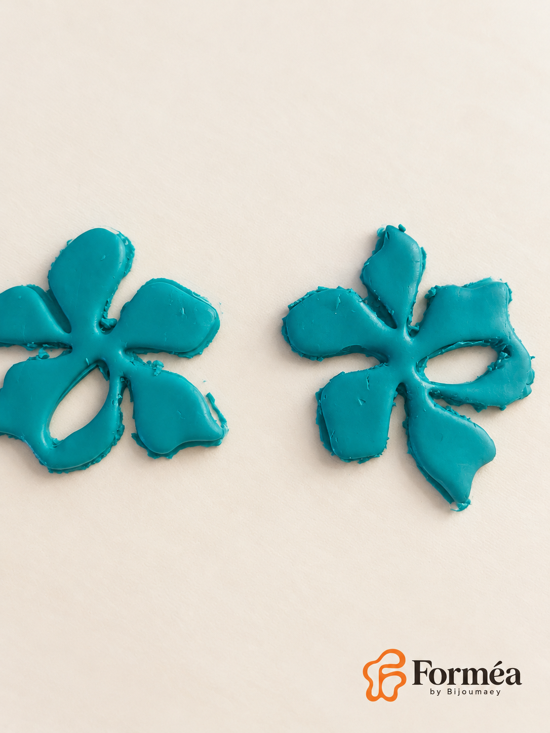 Gros plan de deux découpes brutes en pâte turquoise, celle de gauche partiellement recadrée