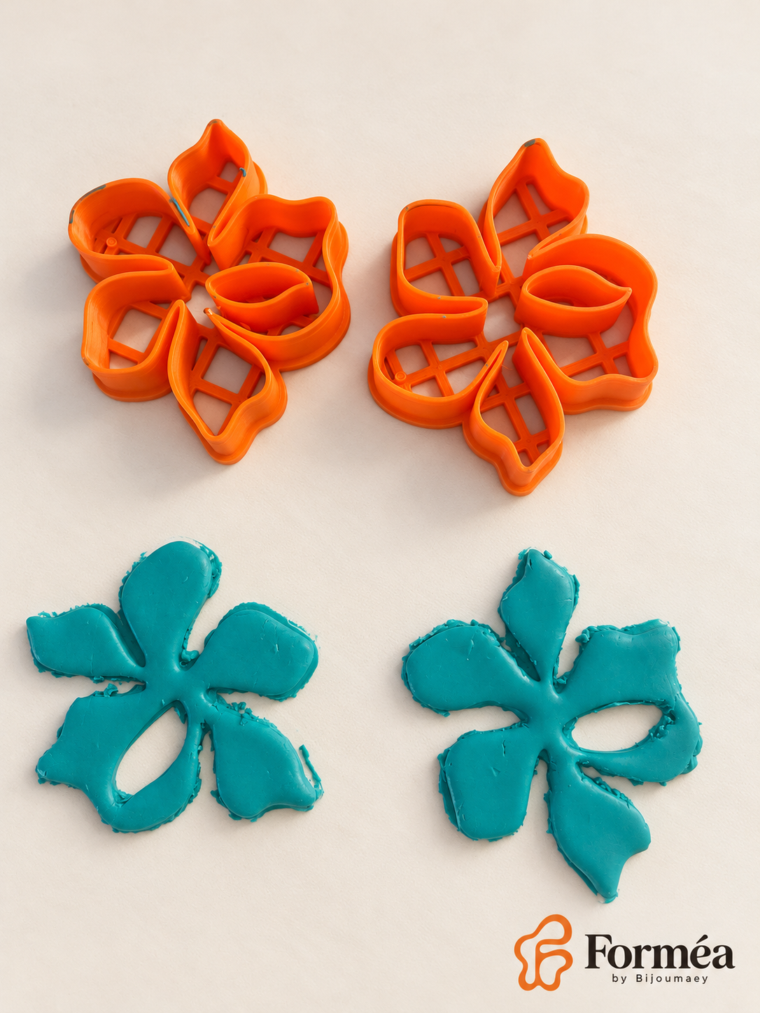 Deux emporte-pièces Fleur organique ajourée orange et deux exemples de découpes brutes en pâte turquoise.