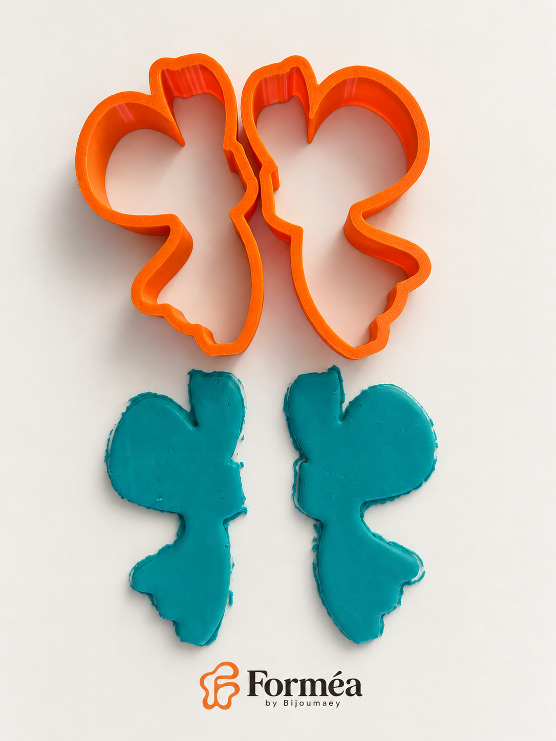 Emporte-pièces Aile de papillon orange avec deux découpes brutes en pâte turquoise, avant les finitions