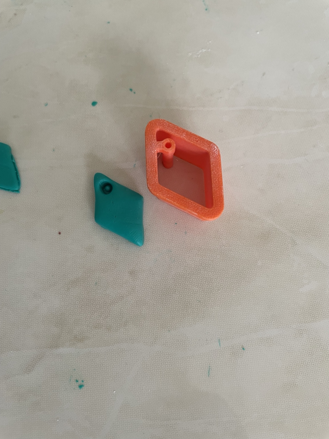 Essai dans la pâte polymère : outil orange et découpe avant finition — photographie réelle de l’atelier Forméa