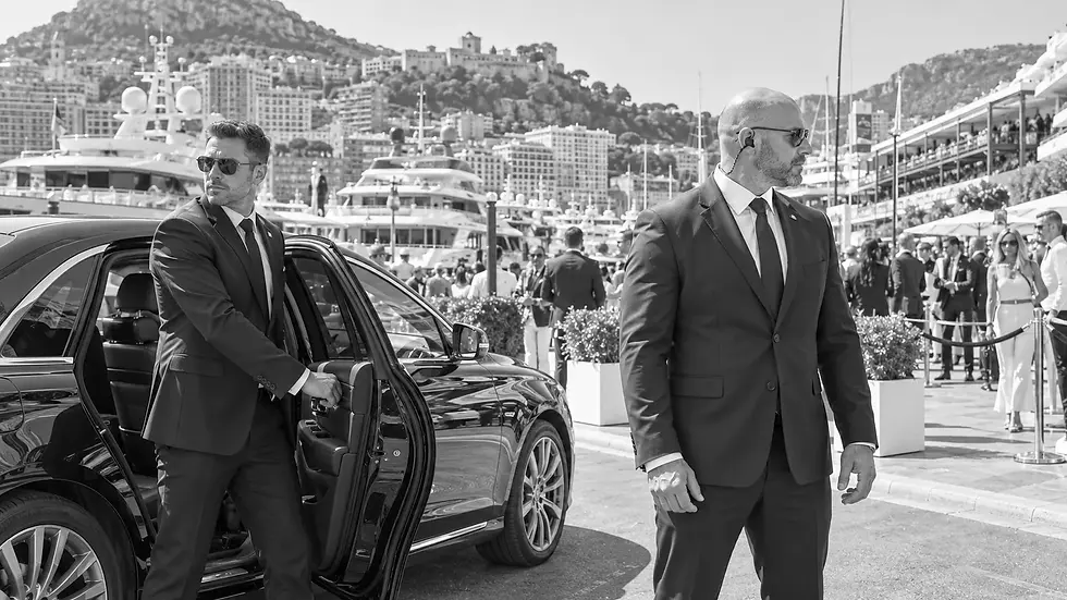 Security driver and close protection officer beside a sedan at Port Hercule in Monaco