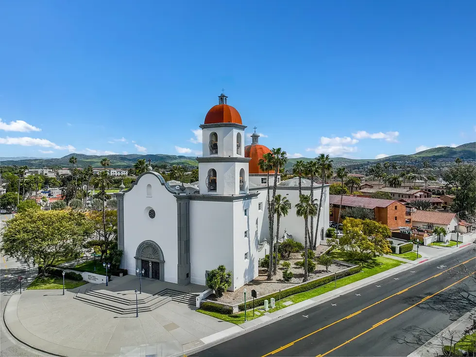 erial view of Mission San Juan Capistrano with red domes and surrounding landscape.