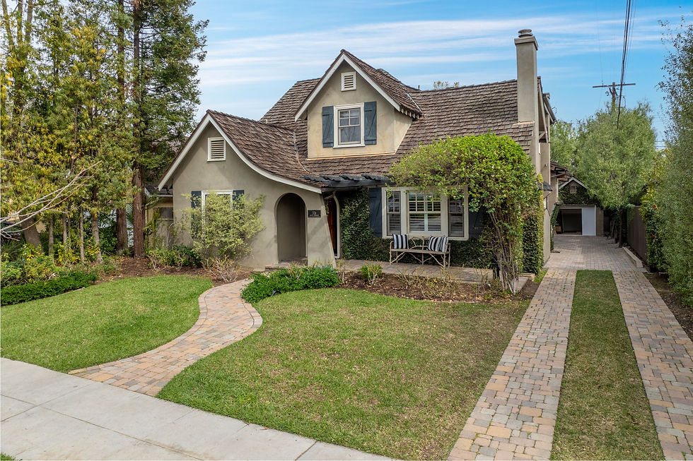 Front exterior with gabled rooflines, an arched entrance and brick garden paths at 326 S Parkwood Avenue in Pasadena.