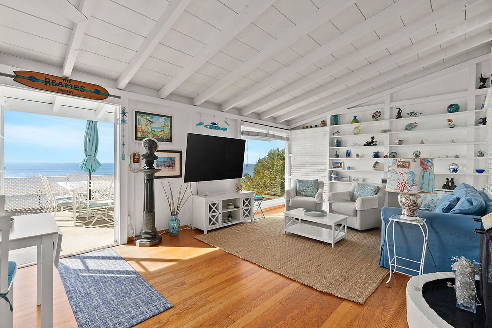 Beach cottage living room with beamed ceiling and patio doors open to the ocean