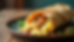 Eye-level view of a breakfast burrito wrapped in foil with eggs, potatoes, and green chile spilling out