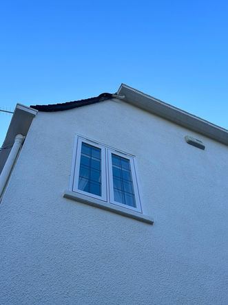 White house exterior, new window installation, white rendering, blue sky.