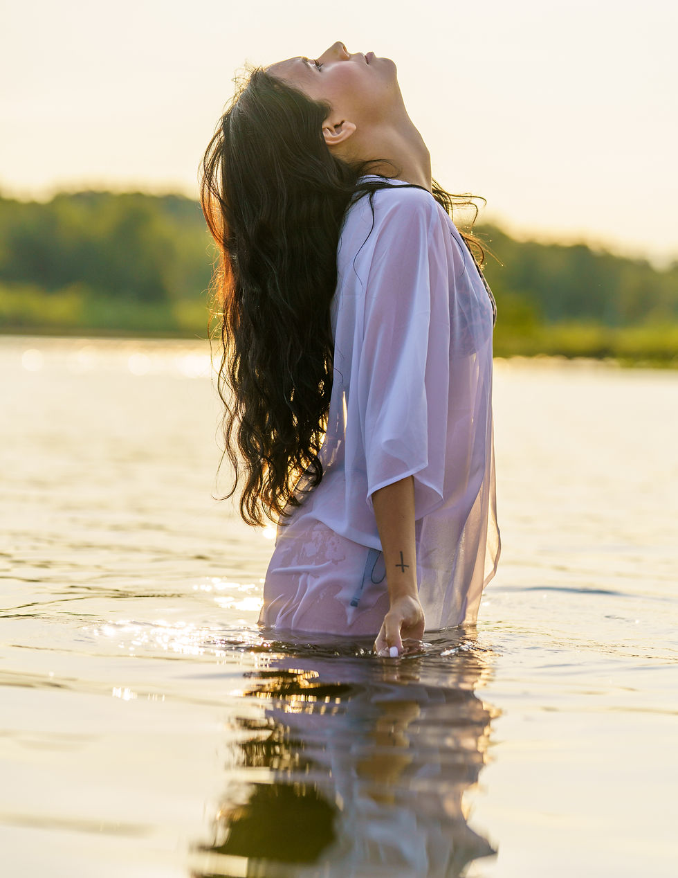 Fashion editorial featuring model Lindsey posing along a quiet Northern Ontario beach during golden hour, styled in bold animal print, classic black, and a flowing sheer cover-up. Warm summer light, sand, and water frame the series, blending confident styling, natural movement, and understated allure.