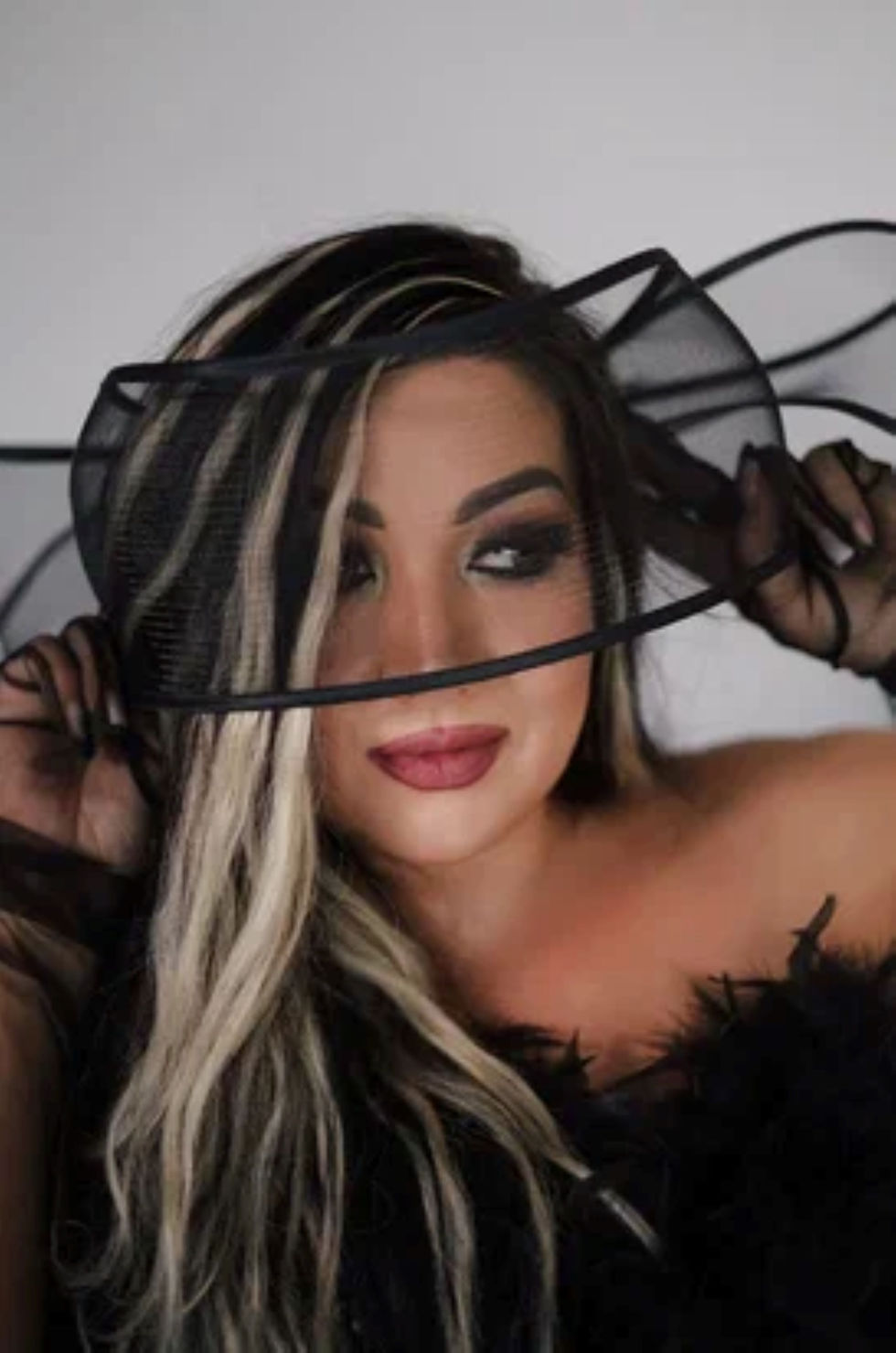 Model Венера Алиева stars in Beautiful Venus, a glamorous studio fashion series featuring dramatic black looks against a minimalist white backdrop. In one portrait, she poses in a voluminous black tulle mini ensemble with sheer sleeves and platform heels; in another, she wears a crystal-embellished black gown with feather detailing and sheer gloves, playfully framing her face with translucent fabric.