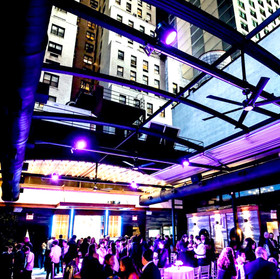 The rooftop at Edison ballroom during cocktail hour at an event, the roof is open and people are mingling