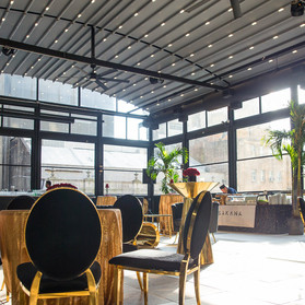 The rooftop at Edison ballroom set for cocktail hour in gold and black, roof not retracted