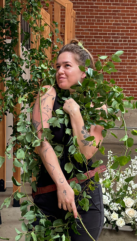 Tayler Jupiter, florist behind Jupiter West Coast Floral wrapped in vines.