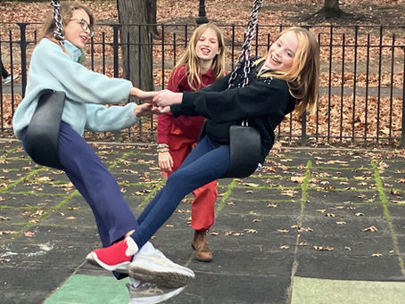 Two girls twisting on swings