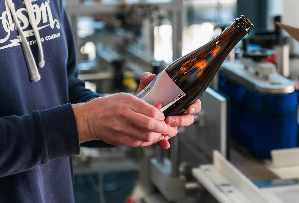 Applying labels to the bottles in preparation for filling — the final steps before Reverie is ready to be shared.