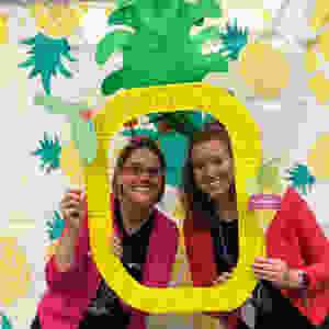 Tracie Snow and Randi Mitchell holding a pineapple cutout.