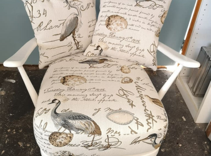 White chair with matching cushions and throw pillows