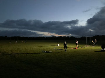 People doing workouts on rugby field at night.jpeg