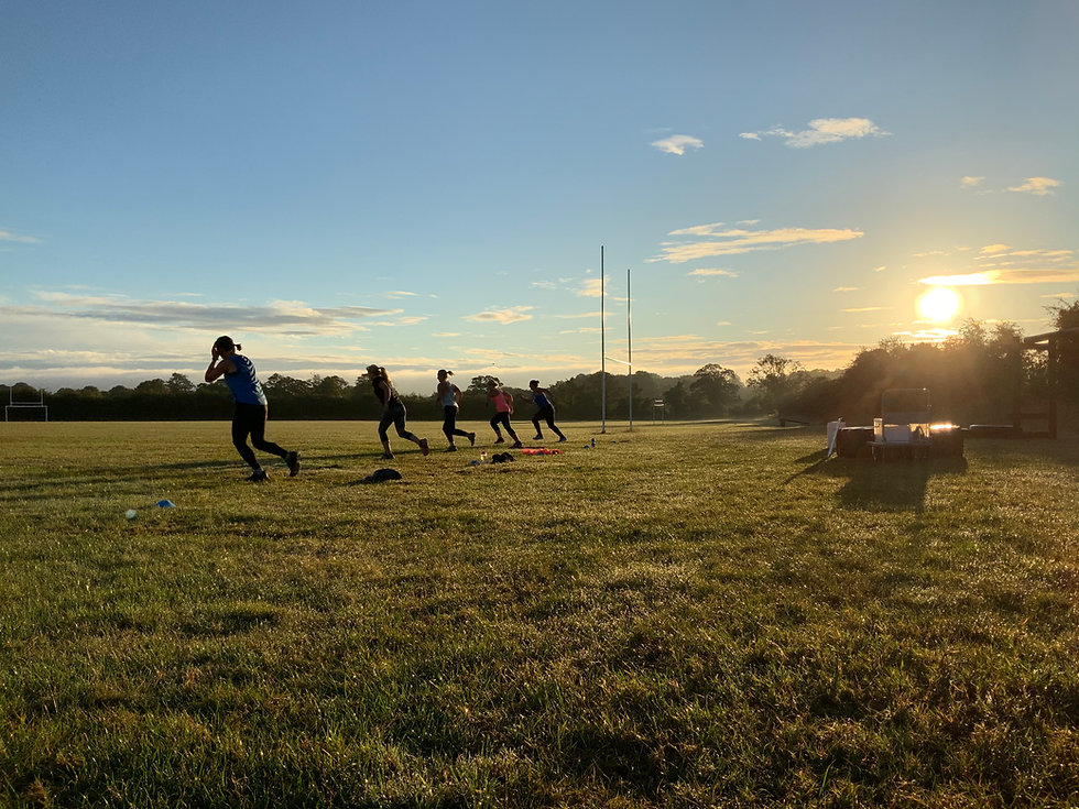 Fitness enthusiasts going through workout as sun rises in background.jpeg