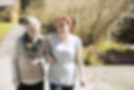 Caregiver and elderly lady walking hand in hand.jpg