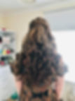 a person's back with long curly hair