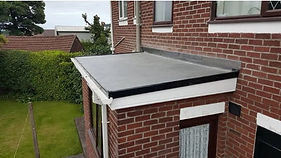 Flat roof extension on a brick house, overlooking a grassy garden