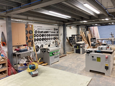 Work table in foreground with equipment behind and garage door at far end of room