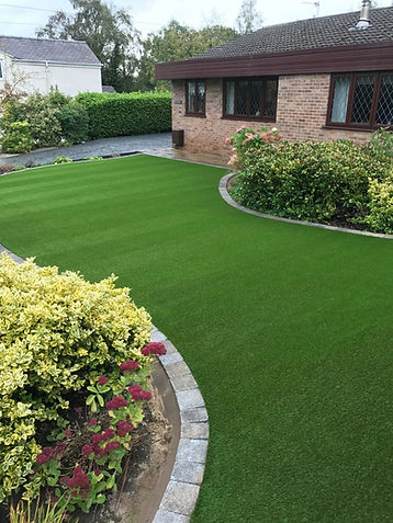 Garden with artificial lawn bordered with block paved pathway.jpg