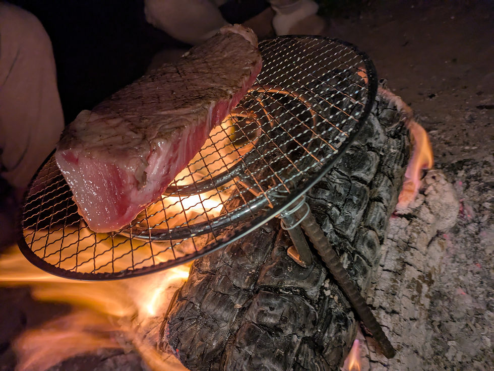 Savoring local Goto beef grilled over a cozy bonfire.