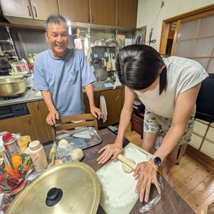 うどん作り体験をする女子と見守る男性
