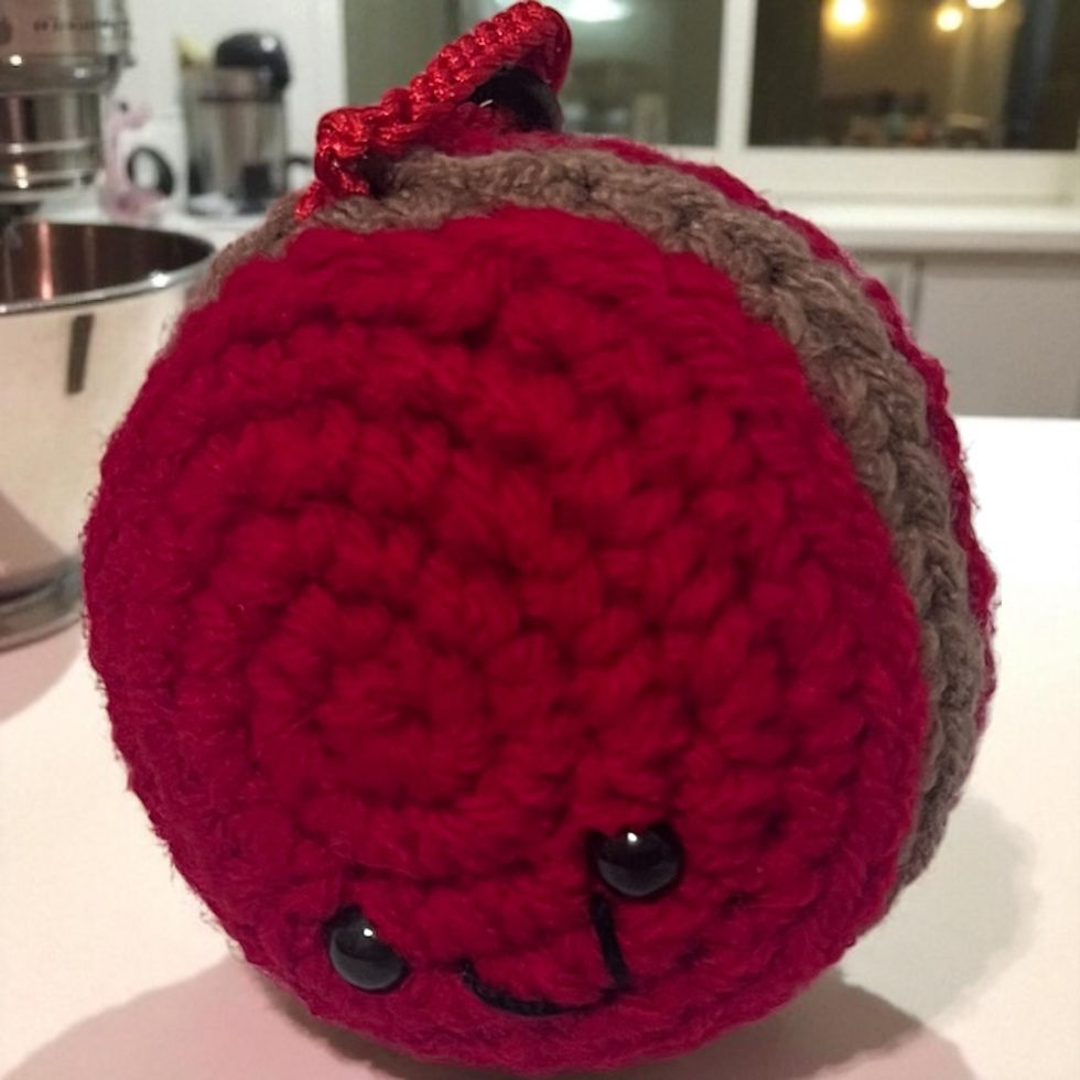 Thumbnail: Handcrafted crochet red macaron with light brown filling keychain, with embroidered mouth and small safety eyes.