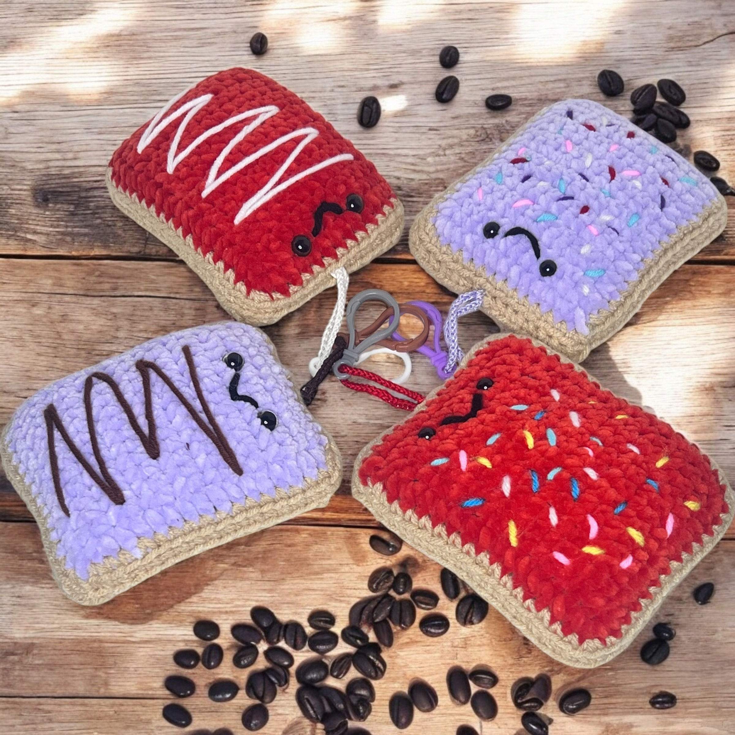 Handcrafted crochet Toasty Tarts bckpack charmsa in various colors, red, purple, & lavender with embroidered frosting.