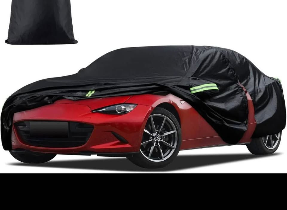 Red sports car with black cover partly on and reflective stripe