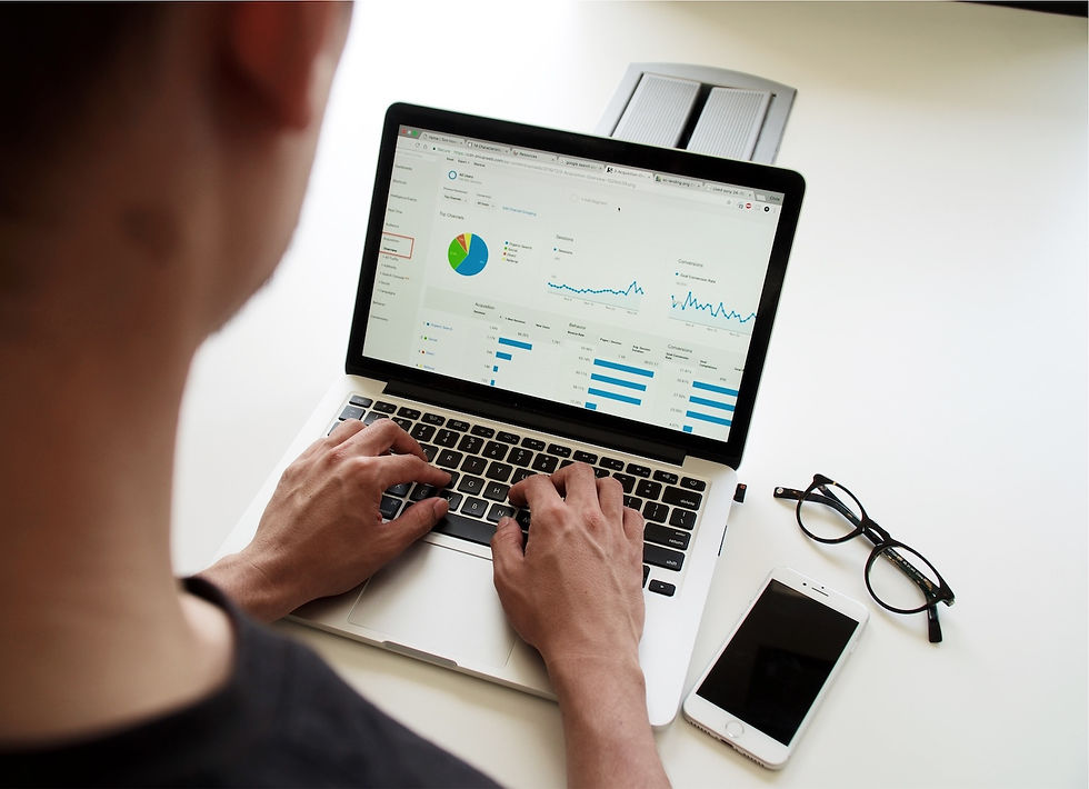 man looking at laptop with graphs on screen