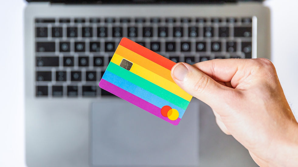 hand holding rainbow credit card above laptop