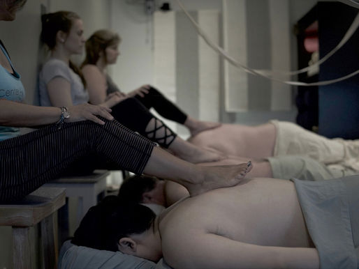 Students learning barefoot massage in Durham NC class