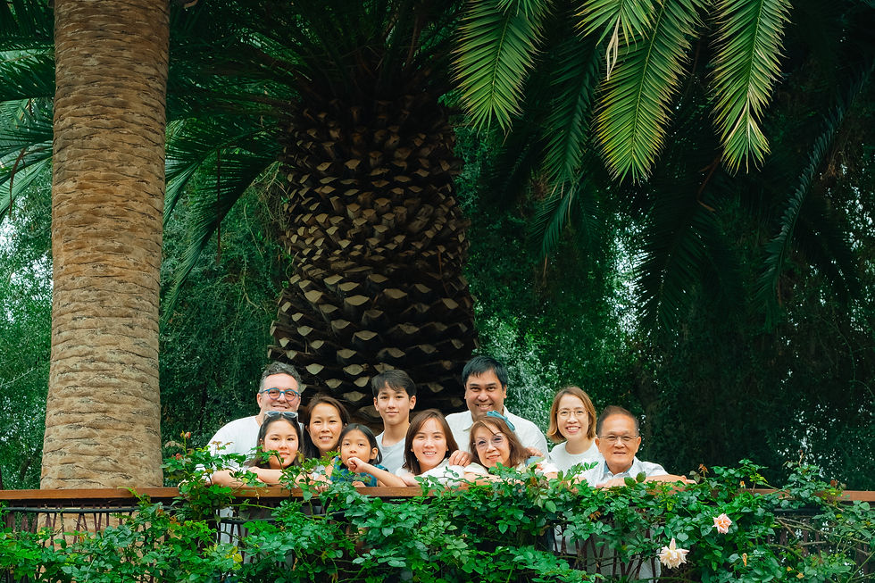 Family photographed together outdoors surrounded by greenery in Singapore
