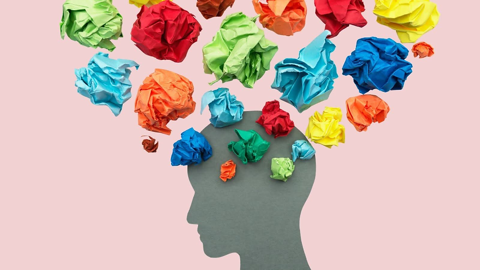 Silhouette of a head with colorful crumpled paper above, suggesting thoughts or ideas, on a pink background.