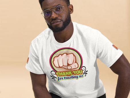 A man wearing a white T-shirt with a bold fist graphic and the message "Thank you for trusting us"