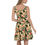 Thumbnail: Back view of a lady wearing a green-leaf pasted skater dress with both hands pointing right