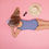 Thumbnail: A little girl wearing a one-piece watercolor kids swimsuit lay on the ground backing the sun
